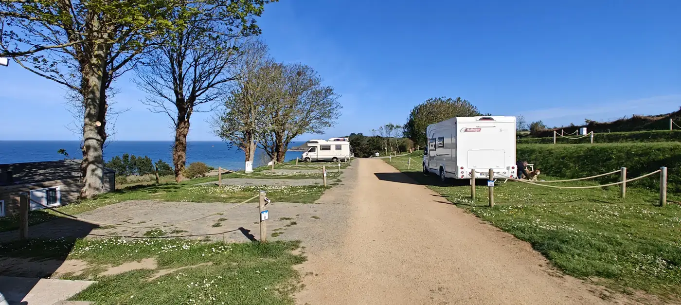 Allées ombragées du Camping Les Tamaris avec la mer en arrière-plan